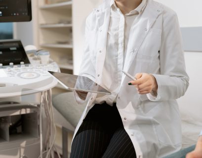 Photo Of Gynecologist Sitting Near Medical Equipment with tablet